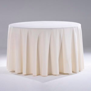 An elegant ivory white round hotel tablecloth featuring structured vertical box pleats draped beautifully over a banquet table