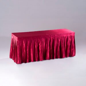An elegant burgundy red pleated hotel table skirt draped over a long banquet table for event setups