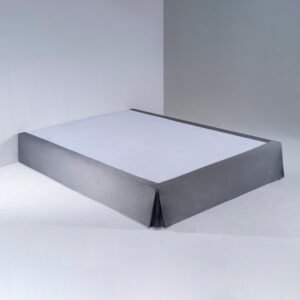 A crisp white hotel mattress fitted with a tight, smooth waterproof fitted sheet under professional lighting