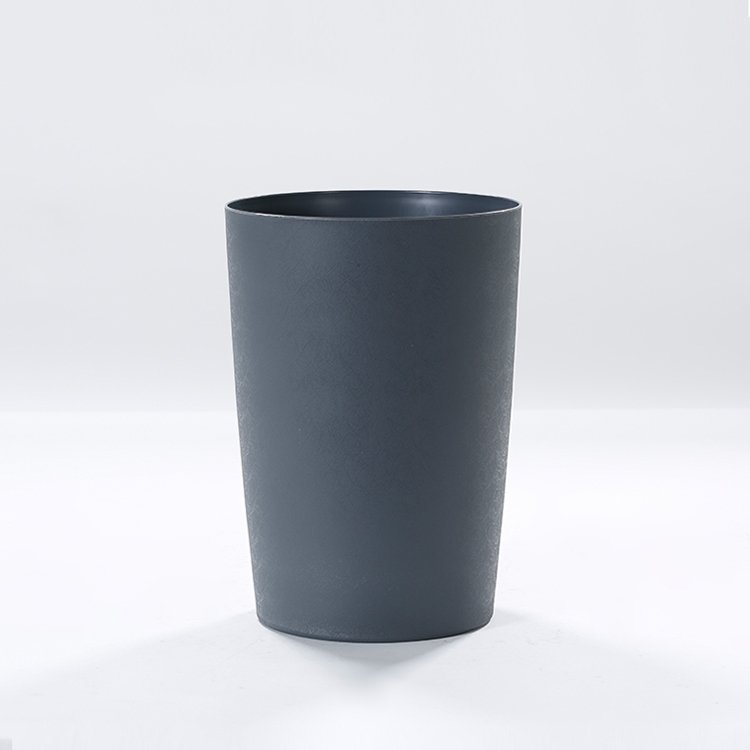Charcoal grey commercial plastic wastebaskets for hotel guestrooms showcasing seamless cylindrical taper and matte finish