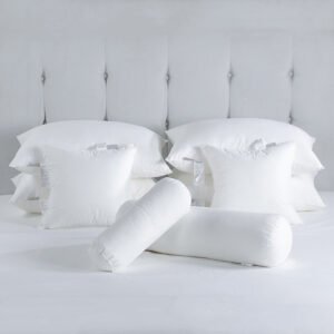 Luxury white hotel down pillow inserts, square decorative cushions, and bolster pillows stacked elegantly on a premium white bed