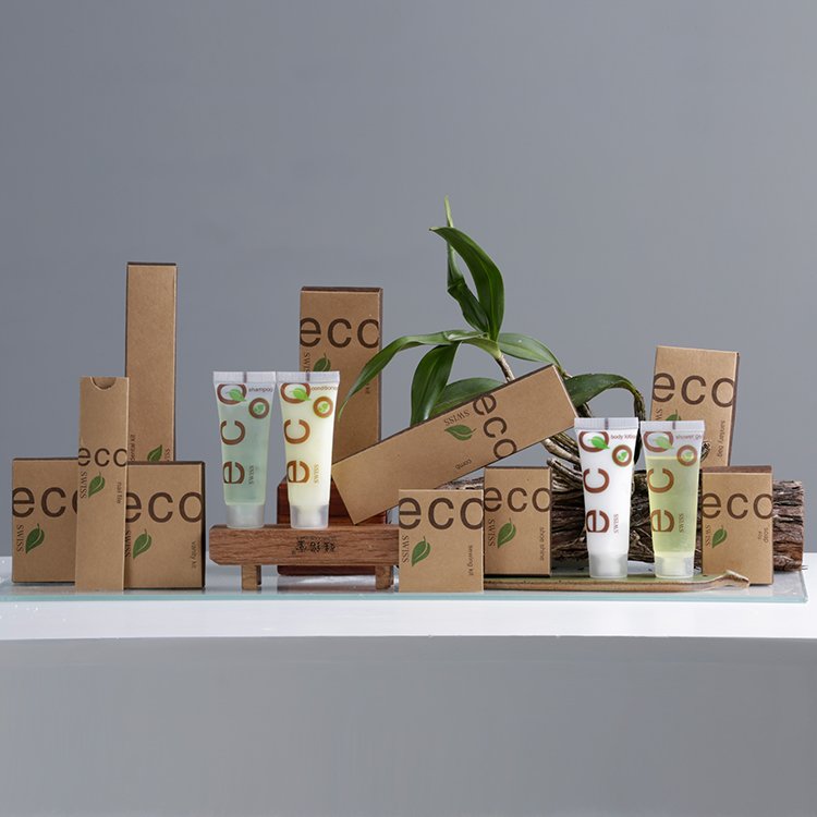 ECO SWISS hotel amenities with brown kraft paper packaging, green leaf design, and matching translucent squeeze tubes