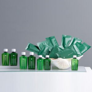 Galaxy Hospitality Green Crystal luxury guest toiletries with matching forest green sachet amenities in a seashell display tray