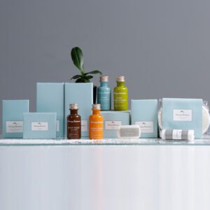 Galaxy Hospitality luxury teal boxed guest room disposable amenity collection with colorful mini liquid toiletries and metallic silver caps