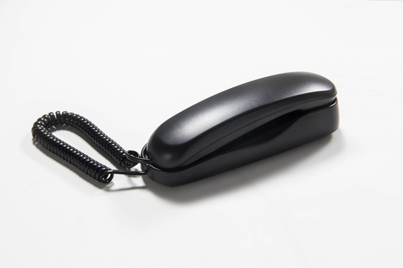 Sleek compact black hotel wall-mounted telephone featuring a slim moisture-resistant handset design