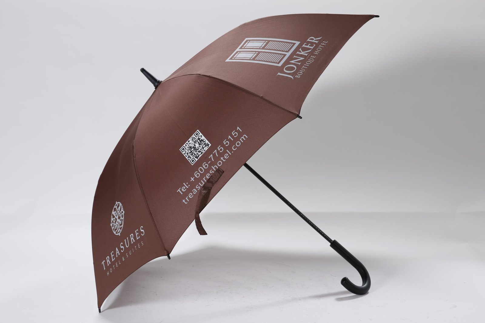 Custom printed black hotel concierge umbrella featuring a comfortable curved handle and white resort logo