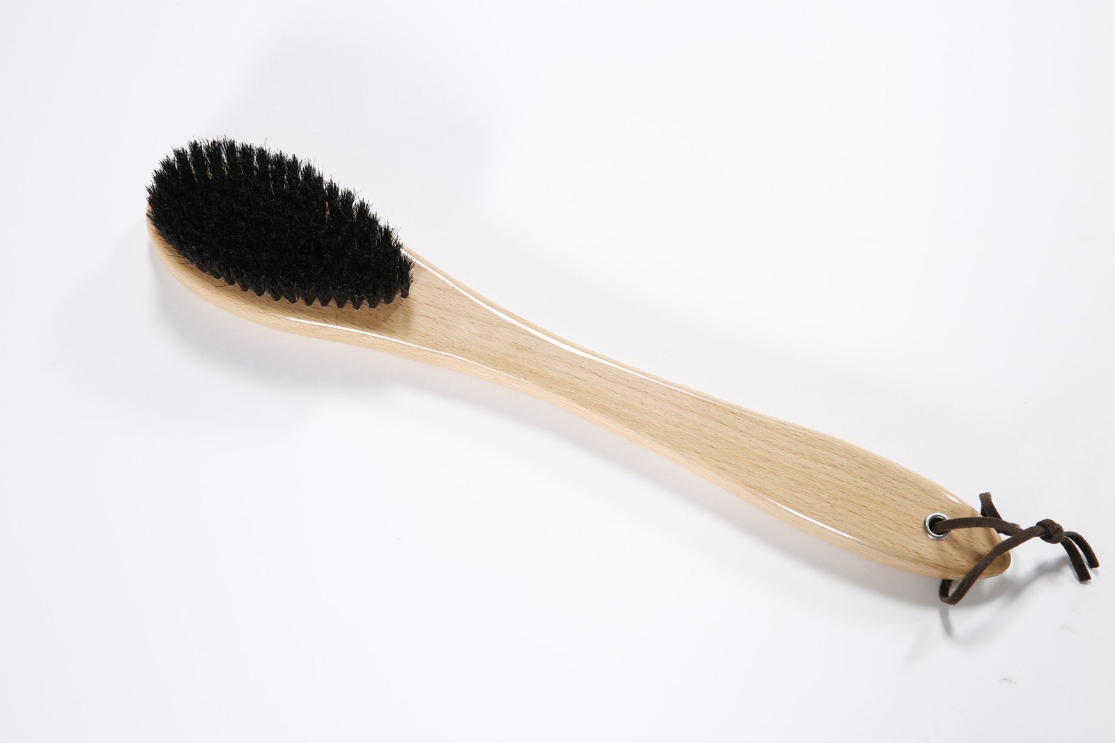 Premium wooden hotel room clothes brush featuring dense black bristles and a leather hanging loop