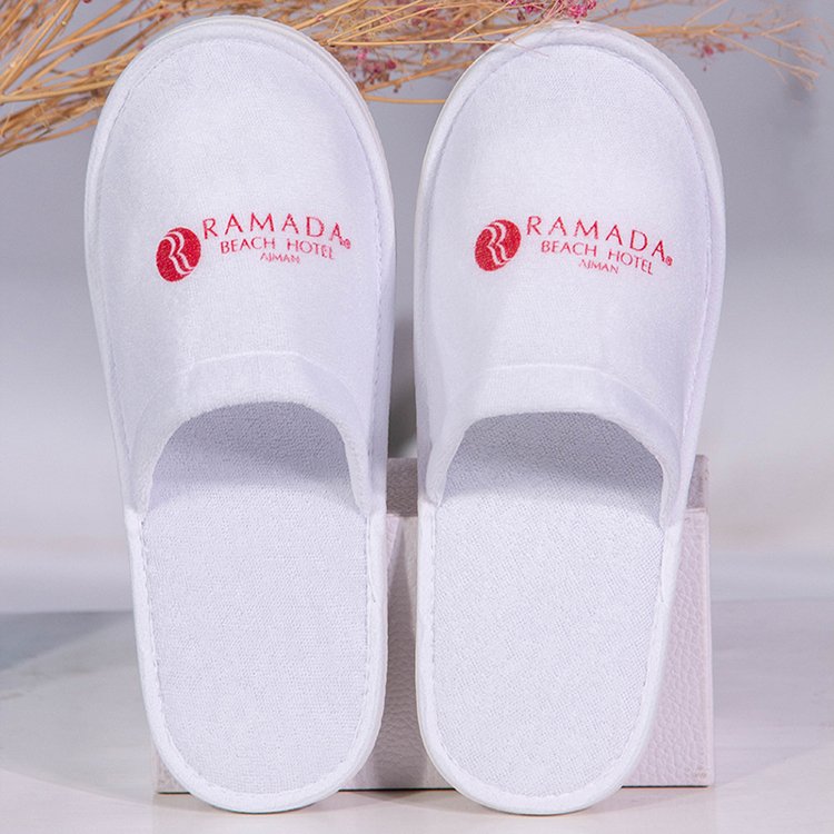 Galaxy Hospitality luxury white closed-toe disposable hotel slippers with red custom embroidered Ramada Beach Hotel logo
