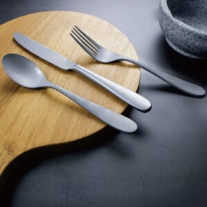 Modern luxury brushed gold flatware set commercial items with a champagne satin finish on a white ceramic plate