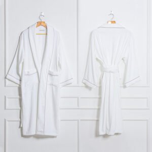 Front and back view of a premium white luxury hotel velour bathrobe with a sheared velvety texture and refined grey piping displayed on hangers