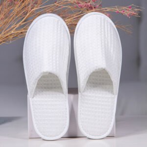 Galaxy Hospitality luxury white closed-toe waffle weave disposable spa slippers on display