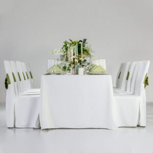 Elegant white banquet table setup featuring green chair bows wedding decorations with matching napkins and white tablecloths