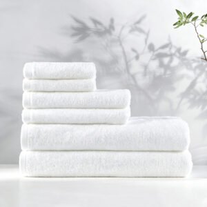 Stacked white luxury hotel towels featuring detailed diagonal twill dobby border accents on a spa vanity