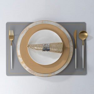 Grey wholesale leather placemat with gold border frame accent set with porcelain tableware and gold cutlery