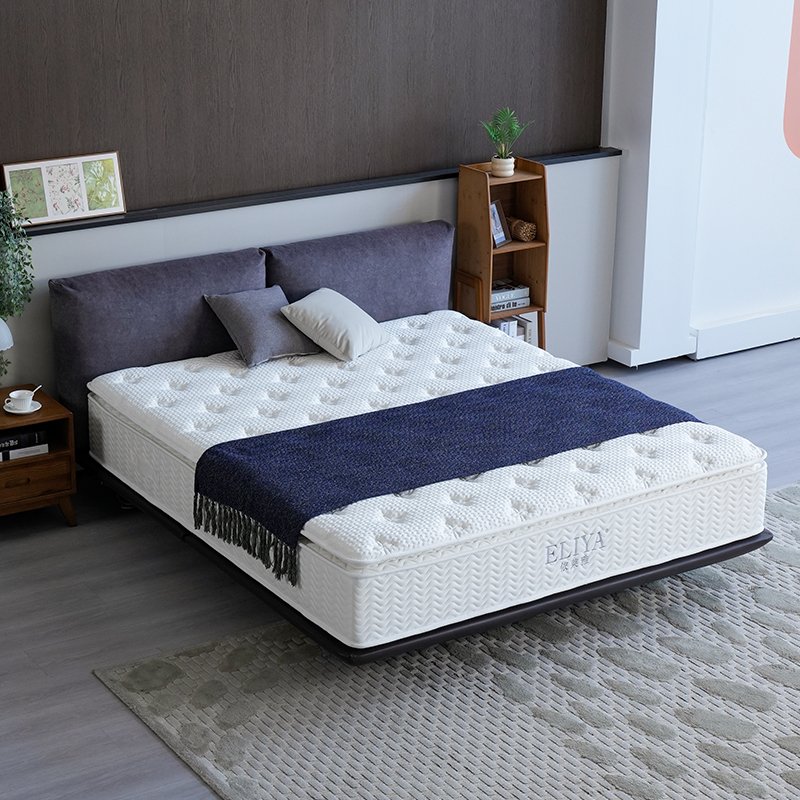 Point-tufted hotel pillow top mattress styled with navy blue runner on a modern dark bed frame