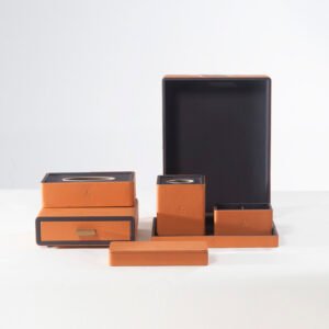 Vibrant orange luxury leather hotel guestroom accessory sets featuring custom embossed logos and dark grey inner trim