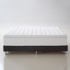 Pure white tufted pillow top hotel mattress with chevron textured sidewall on a black bed frame