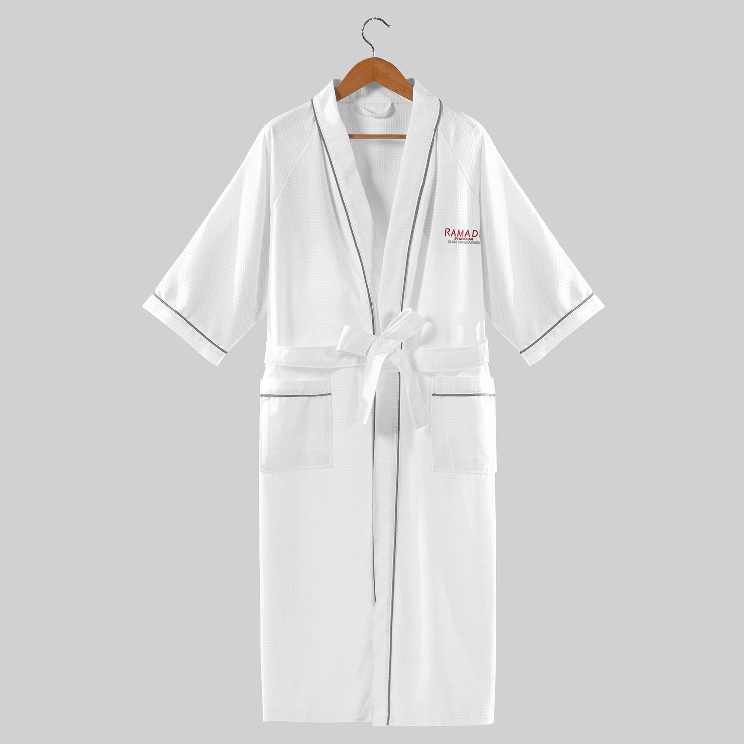 White waffle weave hotel bathrobe with 3/4 sleeves, contrast grey piping, and custom logo embroidery